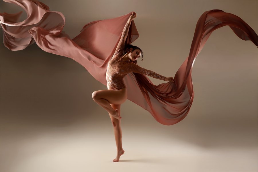 Bailarina en movimiento con tela coral extendida en el aire, Erica Cruz