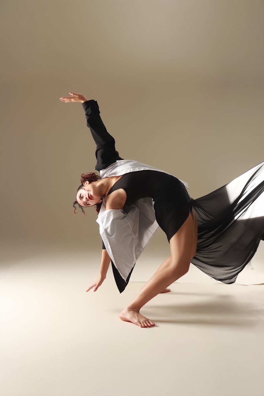 Bailarina con vestido negro y tela en movimiento, Erica Cruz